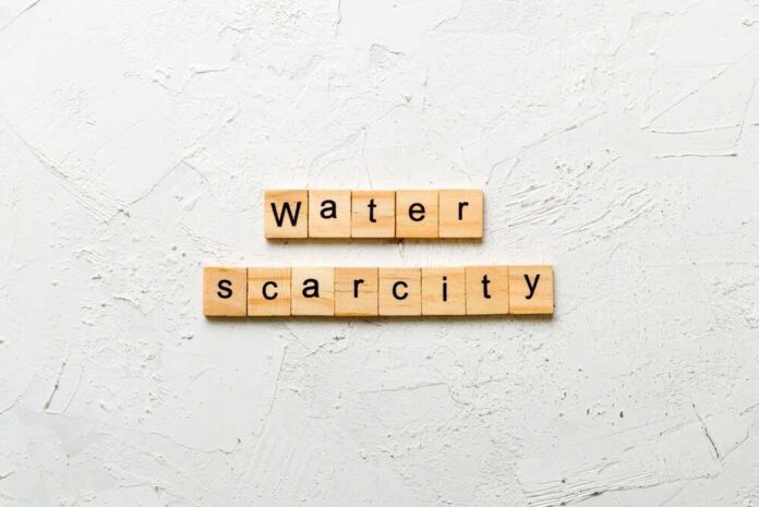Water,Scarcity,Word,Written,On,Wood,Block.,Water,Scarcity,Text Hand filling pitcher with water from faucet.