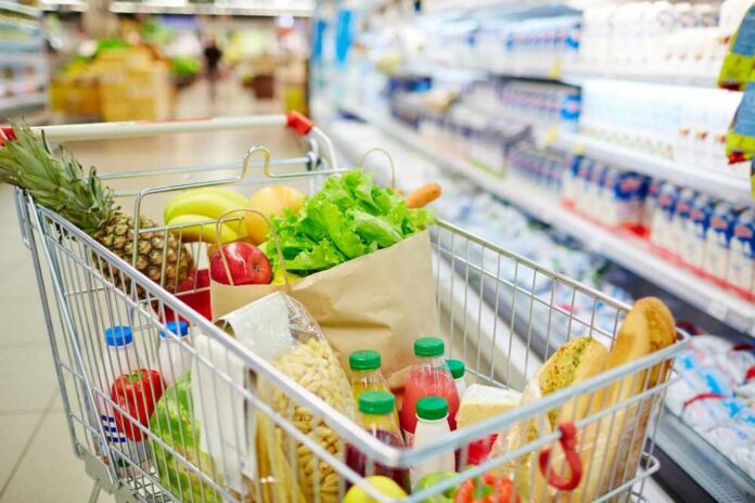 shutterstock_479849773 A shopping cart filled with fresh fruits, vegetables, and groceries