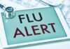 Tablet displaying a flu alert message with a stethoscope nearby