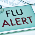 Tablet displaying a flu alert message with a stethoscope nearby