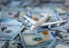 $300K Foot Baths Spark Airport Firestorm Toy airplane on scattered US dollar bills
