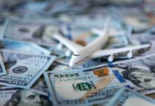 $300K Foot Baths Spark Airport Firestorm Toy airplane on scattered US dollar bills