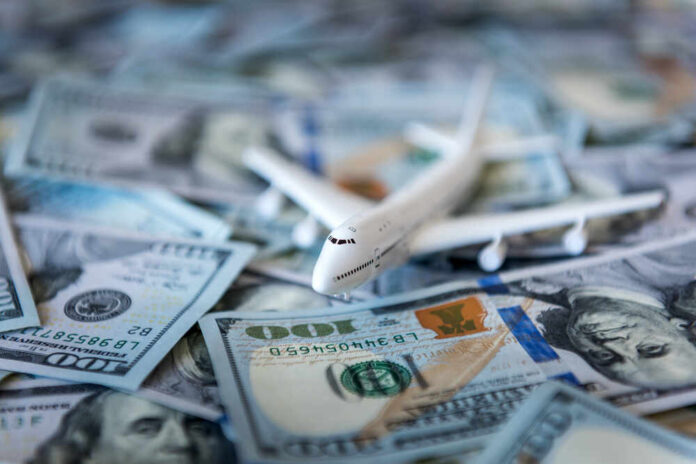 White,Plane,On,Dollar,Cash,Closeup Toy airplane on scattered US dollar bills