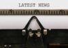 Close-up of a typewriter with a sheet of paper displaying the words 'LATEST NEWS'