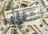 385 Trump Accounts Vanish Overnight WHY? A stack of hundred dollar bills secured with a chain and padlock