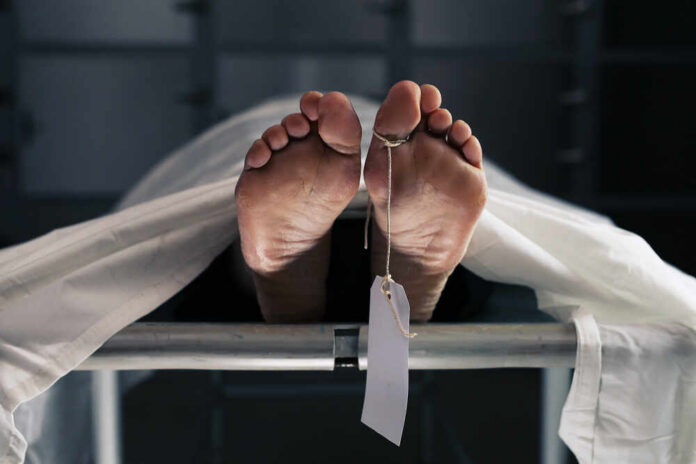 A,Scene,In,The,Hospital,Morgue,Where,Corpses,Are,Taken Feet of a covered body on a morgue table with a toe tag