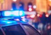Close-up of a police car with blue emergency lights in a city at night