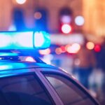 Homicide Charge After Shove Close-up of a police car with blue emergency lights in a city at night