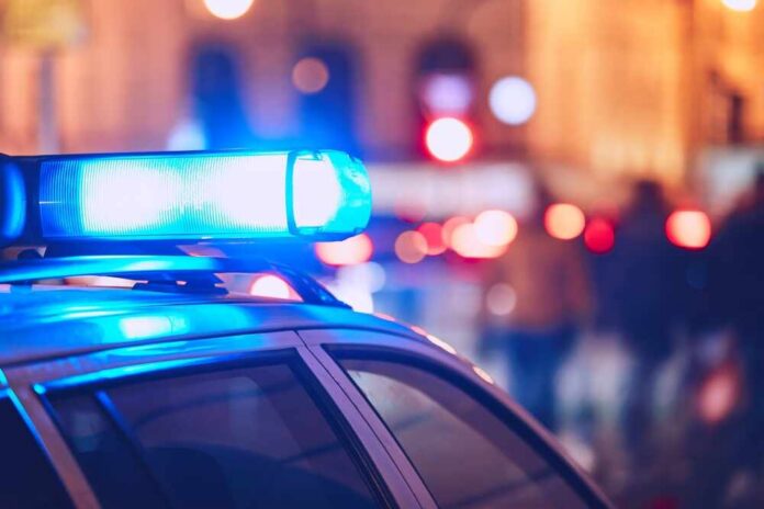 Danger,On,The,Street.,Blue,Flasher,On,The,Police,Car Close-up of a police car with blue emergency lights in a city at night