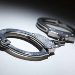 Close-up of metallic handcuffs on a light surface