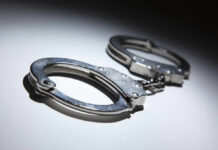Congresswoman’s Son Arrest Spurs Explosive Case Close-up of metallic handcuffs on a light surface