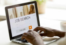 Jobs Shock Stuns Wall Street Person searching for jobs on a laptop.