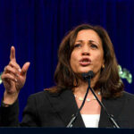 Power Move: Newsom Bows To Kamala Woman speaking passionately at a podium.