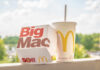 McDonald’s ‘Heist’ Menu Announced: Global Faves Drop A Big Mac box next to a McDonald's drink cup on a ledge