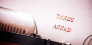 A typewriter with a paper displaying the words 'TAXES AHEAD'