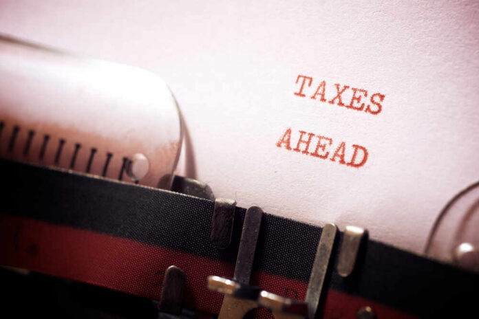 Taxes,Ahead,Phrase,Written,With,A,Typewriter. A typewriter with a paper displaying the words 'TAXES AHEAD'