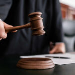 Torture Plot Exposed — Judge Drops Hammer Judge holding gavel in courtroom.