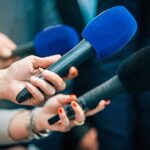 BREAKING: Jurassic Park Icon’s Sudden Farewell Reporters holding colorful microphones