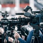 Roller Coaster Record Frenzy at Six Flags Broadcast cameras on tripods at a press event