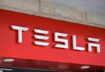 Tesla’s $50K Clock Starts Ticking Tesla logo displayed on a red background