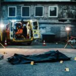 MASS SHOOTING: Drive-Up Gunmen Hit Party Crowd Police investigation at a crime scene with a covered body and evidence markers