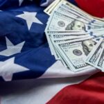 Bombshell: Fed Workers Paid Billions For No Work Stack of hundred dollar bills on an American flag