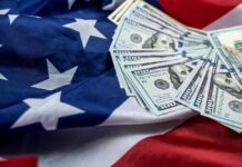 Bombshell: Fed Workers Paid Billions For No Work Stack of hundred dollar bills on an American flag