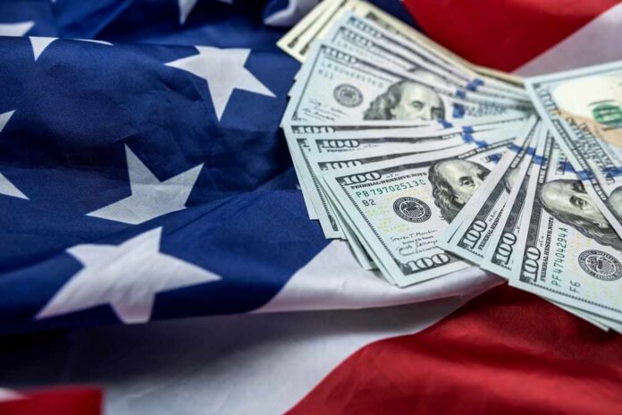Close,Up,Of,American,Flag,And,Dollar,Cash,Money.,Concept Stack of hundred dollar bills on an American flag