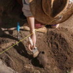 Huge Reveal Under Christianity’s Holiest Site Archaeologist uncovering pottery at a dig site.