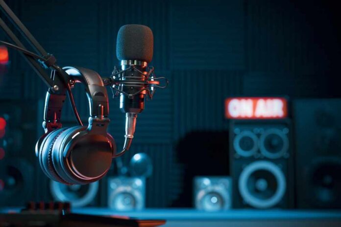 Microphone and headphones in a podcast studio with speakers in the background