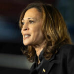 Kamala Harris speaking at a microphone