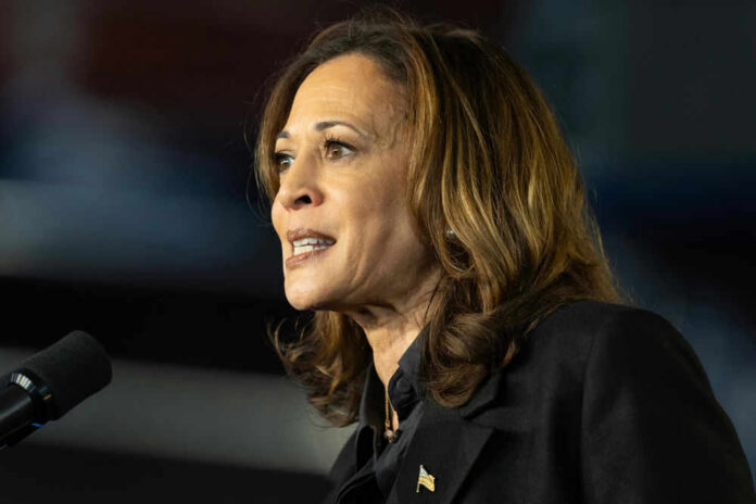 shutterstock_2517436095 Kamala Harris speaking at a microphone