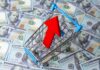 Shopping cart with red upward arrow on US hundred dollar bills