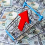 Fast-Food Price Shock Sparks Deal Frenzy Shopping cart with red upward arrow on US hundred dollar bills