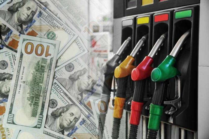 Fuel,Price.,Gas,Filling,Station,And,Dollar,Banknotes,,Double,Exposure Fuel pump nozzles next to spread of U.S. hundred-dollar bills