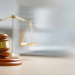 Murder Case CRACKS — Jury Drops Bomb A wooden gavel and scales of justice on a desk