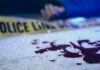 Surf Trip Turned Deadly — Trial Explodes Blood on pavement with police tape and a hand in the background