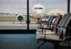 Airport Chaos Erupts — Thousand Flights Halted View of an airplane from an airport waiting area