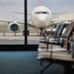 Airport Chaos Erupts — Thousand Flights Halted View of an airplane from an airport waiting area