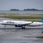 Airline Shake-Up: JetBlue Ups the Game jetBlue airplane taxiing on a wet runway near the coast