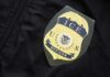 Close-up of an ICE officer badge on a black jacket