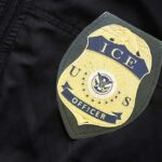 Trump Yanks ICE Pick – Hill Explodes Close-up of an ICE officer badge on a black jacket
