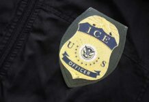 Trump Yanks ICE Pick – Hill Explodes Close-up of an ICE officer badge on a black jacket