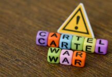 Drug Cartel Recruits From Drone Schools Colorful letter blocks spelling 'CARTEL' and 'WAR' with a warning sign