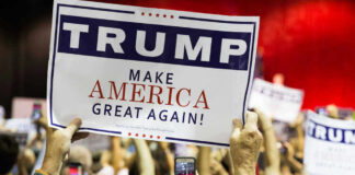 People holding Trump Make America Great Again signs.