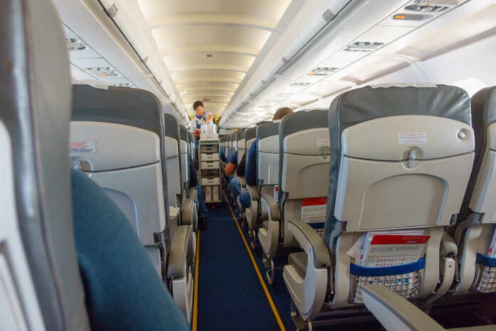 Steward,Offers,Food,And,Drinks,To,Economy,Class,Passengers,On