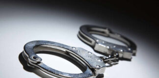 Close-up of metallic handcuffs on a light surface