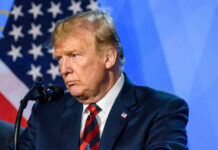 Poll Shock: Trump Approval Craters Donald Trump speaks at a podium.