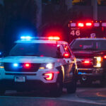 Ambush Rocks Dem Stronghold Police car and ambulance with flashing lights nighttime