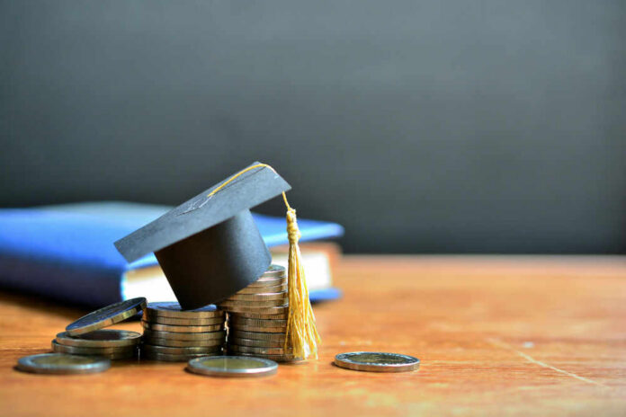 shutterstock_1427912792 Graduation cap on top of coins to represent student loans